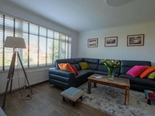 Una sala de estar con un sofá azul y una mesa. en Greenridge, en Totland
