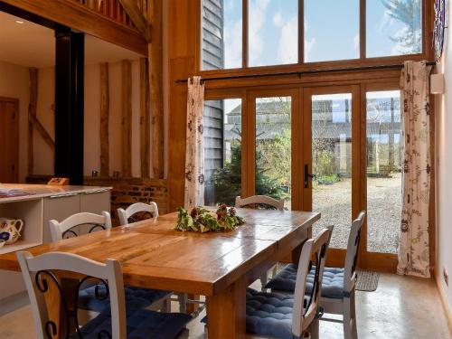 Un comedor con mesa y sillas de madera. en Ivy Todd Barn, en Ashdon