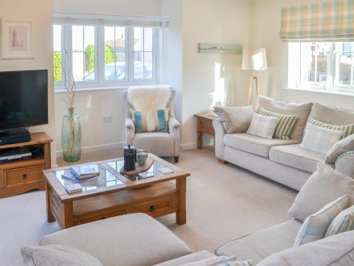 ein Wohnzimmer mit zwei Sofas und einem Fernseher in der Unterkunft Good Tides in Beadnell