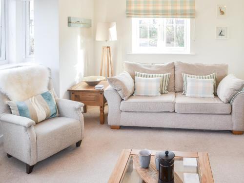 ein Wohnzimmer mit einer Couch und einem Sessel in der Unterkunft Good Tides in Beadnell