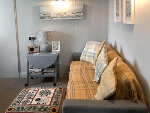 ein Schlafzimmer mit einem Sofa und einem Tisch mit einem Schreibtisch in der Unterkunft Bramley Lodge Annex in Clenchwarton