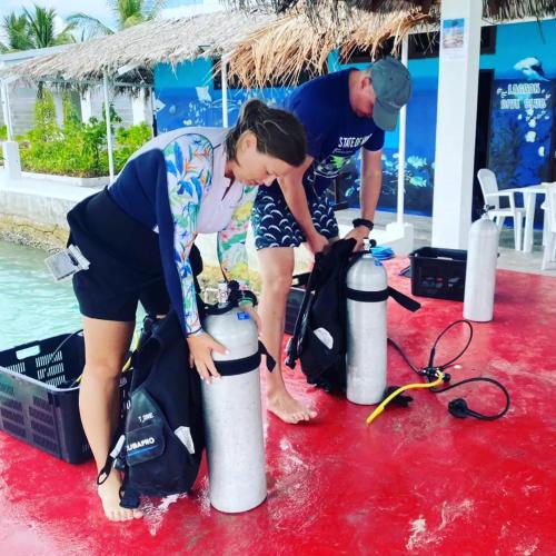 a couple of people standing next to two water hydrants at Lagoon View in Bodufolhudhoo