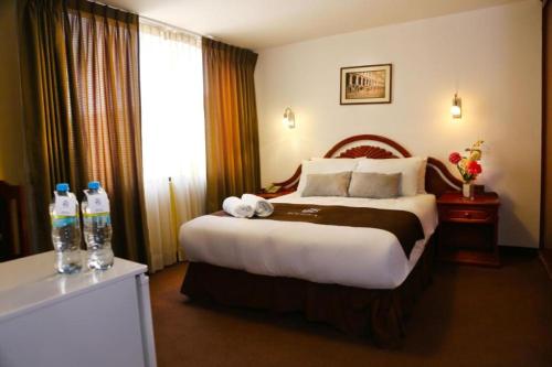 a hotel room with a bed and two bottles of water at Hoteles Riviera Cayma in Arequipa