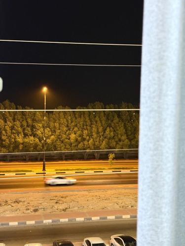 a car driving down a road at night at المنظر الجميل للشقق الفندقية in Al Jubail