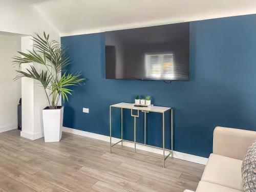 a living room with a blue wall and a table at The Old Stable in Gorfield