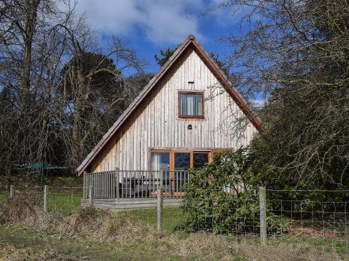 a barn with a fence in front of it at Lime Tree Cottage in Oakley