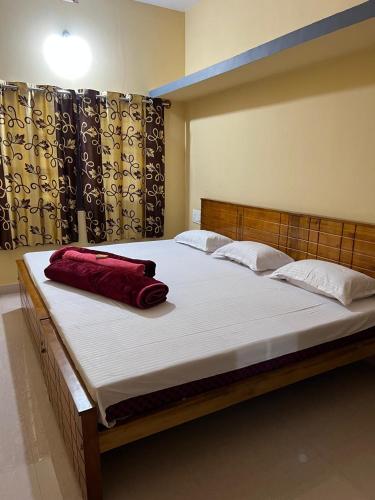 a large bed with a red pillow on top of it at Coorg Mountain Breeze Homestay in Madikeri