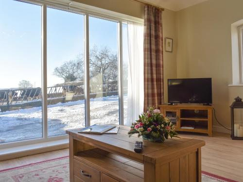a living room with a large window and a television at Calf House Cottage in Sedgefield