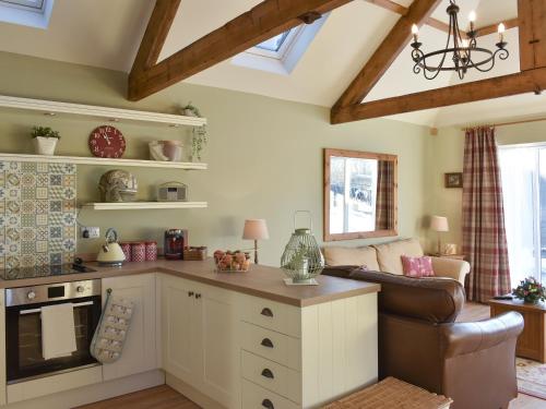 a kitchen with a living room with a couch at Calf House Cottage in Sedgefield