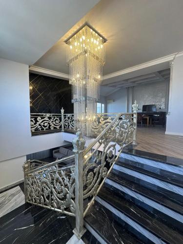una scala con un lampadario in una casa di Penthouse Panorama a Baku