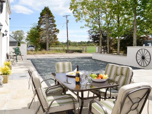 una mesa con un bol de fruta en el patio en Greengill Farm Holiday Cottage - Ukc2768, en Gilcrux