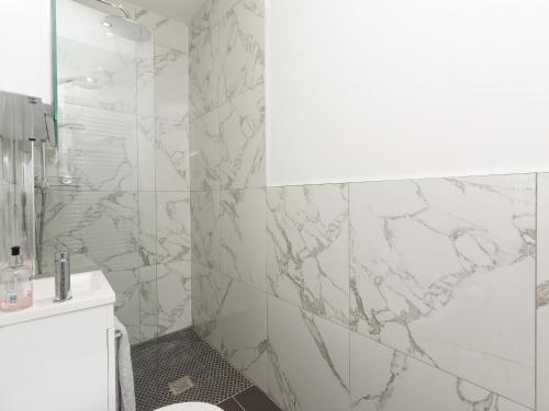 a bathroom with marble walls and a shower with a toilet at Inverspey in Kingston