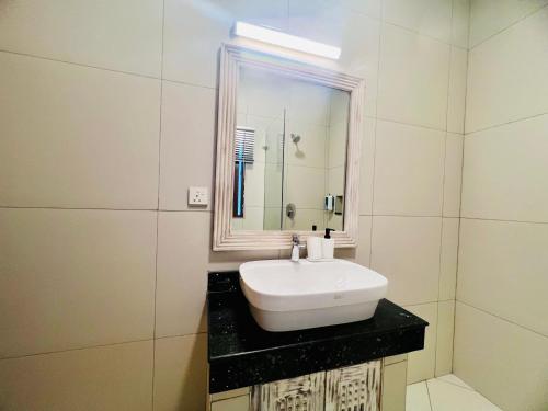 a bathroom with a white sink and a mirror at Jumeirah Malindi Hotel in Malindi