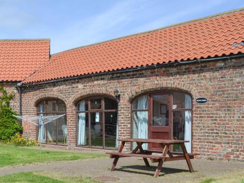 a wooden bench in front of a brick building at Jenny Wren in Flamborough