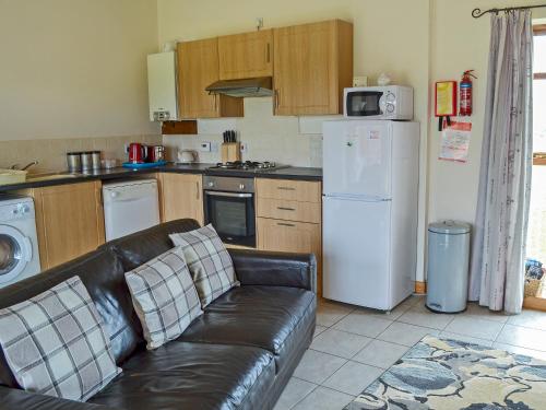 a kitchen with a couch and a white refrigerator at Jenny Wren in Flamborough
