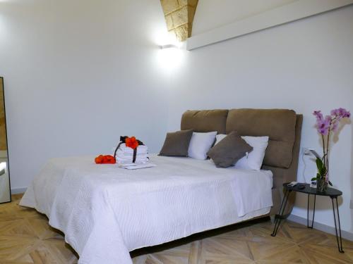 Un dormitorio con una cama blanca con flores. en Leopardi B&B Brindisi Historic Center, en Brindisi