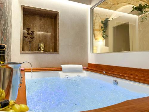 baño con bañera de agua azul en Leopardi B&B Brindisi Historic Center, en Brindisi