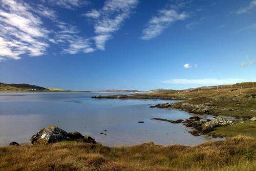 a large body of water with rocks in a field at Sandwick Bay Guest House in Stornoway