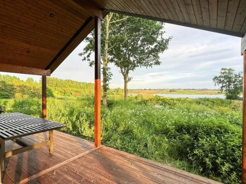 a porch with a table and a view of a lake at 12 person holiday home in Millinge in Millinge