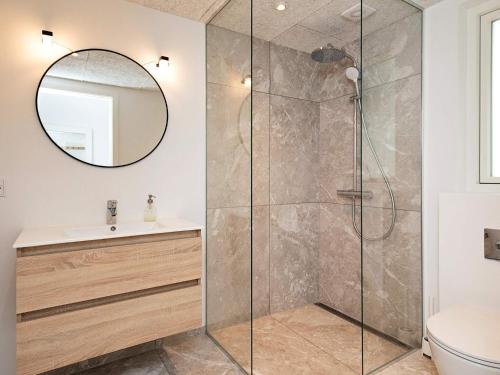 a bathroom with a shower with a sink and a mirror at 12 person holiday home in Millinge in Millinge