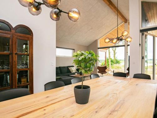 a dining room with a wooden table with a potted plant at 12 person holiday home in Millinge in Millinge