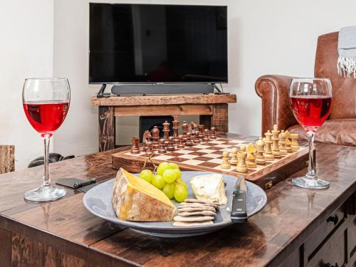 a table with a chessboard and wine glasses on it at Coed Mawr in Betws-y-coed