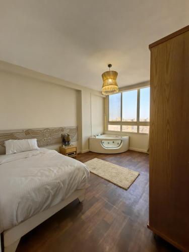 a bedroom with a bed and a tub and a window at Lamour GEM Pyramids View Hotel & Jacuzzi in Cairo