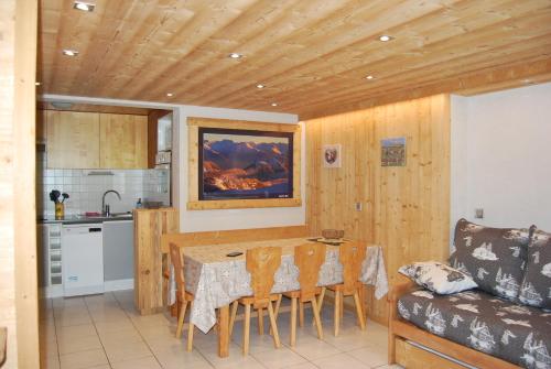 Una cocina con una mesa y sillas en una habitación. en Vieille Bergerie 1, en Le Fernuy