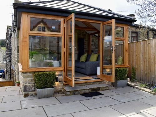 a wooden gazebo with a couch in it at Little Plumtree in Addingham