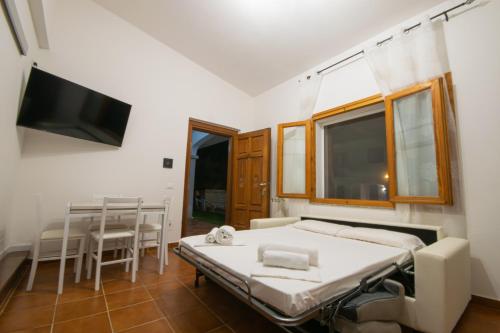 a bedroom with a bed and a tv and a table at Mera House in Posada
