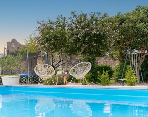 two chairs and a table next to a swimming pool at Lavanda Apartments & Room in Sveti Lovreč Pazenatički