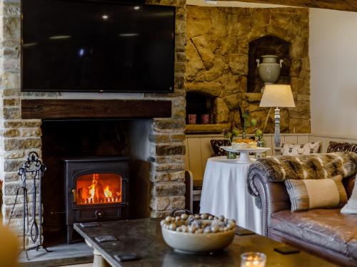 a living room with a fireplace with a flat screen tv at The Grousemoor in Llandegla
