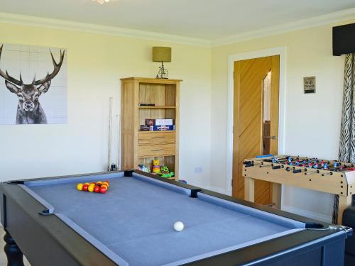 a living room with a pool table and deer head on the wall at Wheatfield House in Kilmaurs