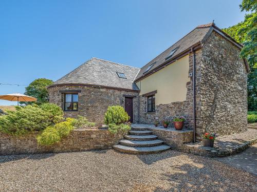 a stone house with a stone path leading to a door at The Old Roundhouse in Hartland