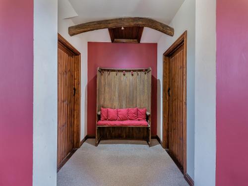 a red bench in a pink room with a curtain at The Old Roundhouse in Hartland