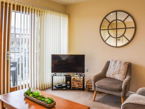 a living room with a television and a chair and a table at Swan House in Carnforth