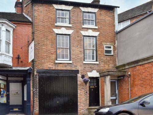 a red brick building with a black garage at Dusty House in Ashbourne