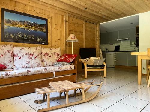 Una sala de estar con un sofá y una cocina. en Vieille Bergerie 2, en Le Fernuy