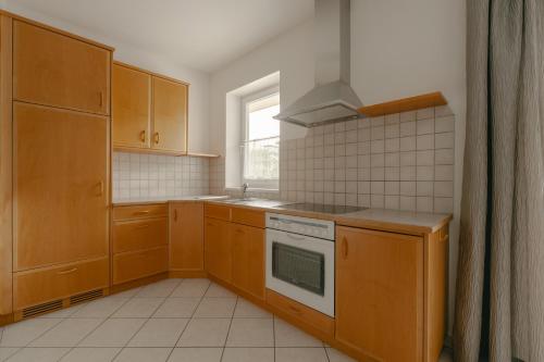 a kitchen with wooden cabinets and a stove at Hotel Post Gries in Bolzano