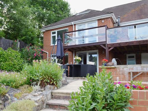 a brick house with glass doors and a patio at The Cottage in Fairlight