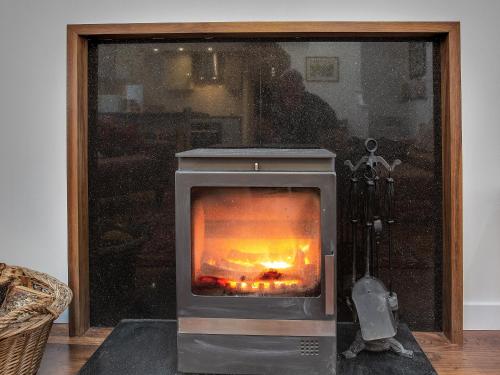a fireplace with a fire in it in a room at The Old Barn - Uk40948 in Auchtermuchty