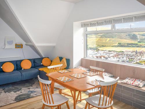 a living room with a table and a blue couch at Beach View in Woolacombe