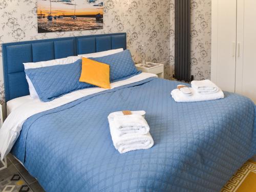 Un dormitorio con una cama azul con toallas. en The Den, en Herne Bay