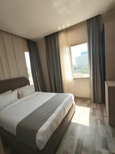 a bedroom with a large bed and a large window at Elevana Boutique hotel in Cairo