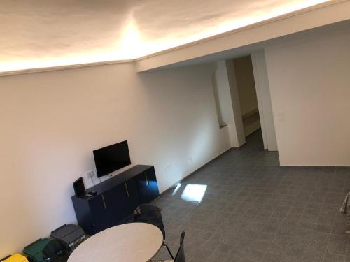 SuiteSweetGiovanna في تاورمينا: غرفة مع طاولة وتلفزيون على الحائط