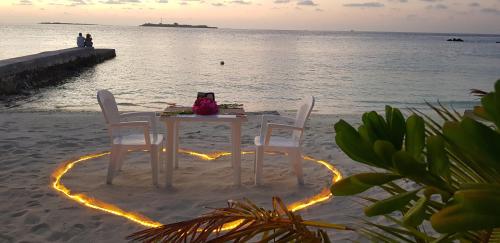 a table and chairs on the beach with a heart at Lagoon View in Bodufolhudhoo
