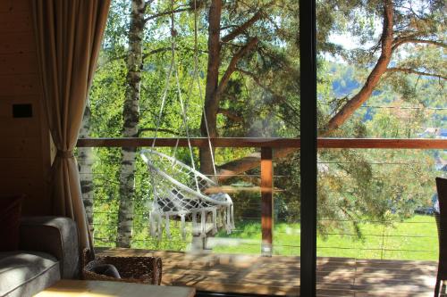 a view from the living room window of a white chair at Molika Forest House in Kolašin
