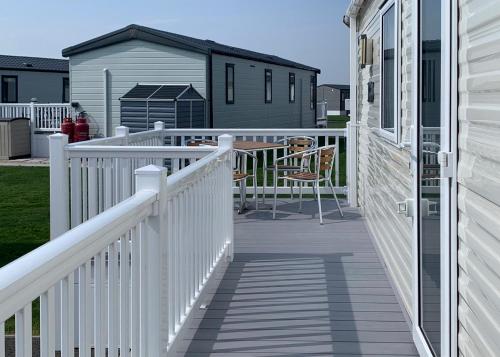 a white railing on a porch with a house at Riverside Holiday Village in Uphill