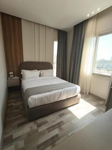 a bedroom with a bed and a large window at Elevana Boutique hotel in Cairo