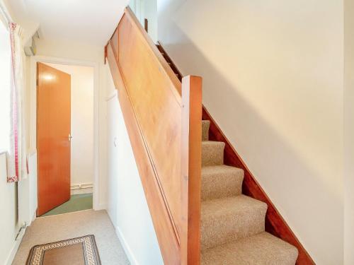 a staircase in a home with a wooden stair case at Sunnyside in Colkirk